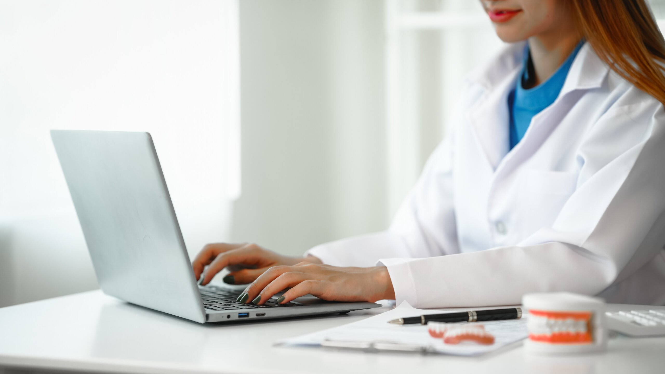 Engaging dental consultation with a female model discussing men's dental appointments at a professional desk meeting, emphasizing oral health and dental care for men.